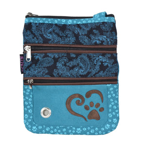 Gassi-UmhĂ€ngetasche aus Stoff TĂŒrkis, Schwarz mit Paisley und kleinen Pfoten Prints. Vorne verziert ein  Herz, Pfoten AufnĂ€her die Tasche. Diese Tasche verfĂŒgt ĂŒber ein Hauptfach und zwei ReiĂverschlussfĂ€cher vorne mit Metallöse zur Entnahme von Hundekotbeuteln