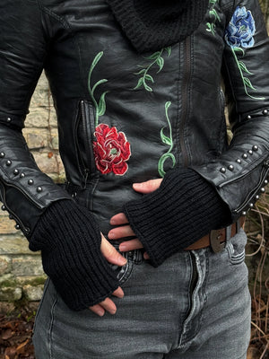 Nahaufnahme Hände: Model präsentiert Handstulpen Mahalaxmi 01 aus Schurwolle mit Fleeceeinlage und Daumenspalte in Schwarz.