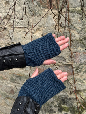 Nahaufnahme Händ vor einer Mauer: Model präsentiert Handstulpen Mahalaxmi 52 aus Schurwolle mit Fleeceeinlage marineblau.