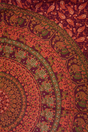 Detailansicht der indischen Mandala-Decke mit Elefantenmotiv in Orange, Rot und Grün auf bordeauxrotem Hintergrund
