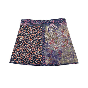 Hinteransicht: Wenderock aus Baumwolle Blau- Schwarz mit Blumen Muster. Kleines Einsteckfach vorne, Umfang ist einstellbar mit gläsernen Druckknöpfen am Rockbund.