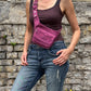 Nijens Bauchtasche Dublin aus Stoff in Fuchsia mit floralem Muster, getragen von einem Model.