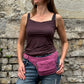 Nijens Bauchtasche Dublin aus Stoff in Fuchsia mit floralem Muster, getragen von einem Model, mit verstellbarem Hüftgurt und Fronttasche.