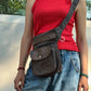 Braun-graue NIJENS Super-Hannover Gassi-Tasche im Vintage-Look mit Lederdetails und Herz-Pfoten-Prägung, als Crossbody-Tasche getragen.