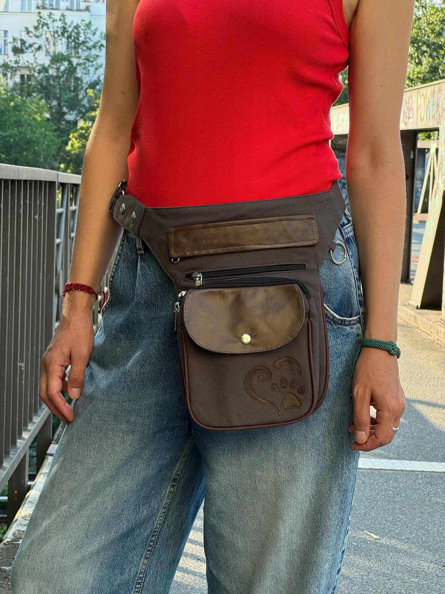 Braun-graue NIJENS Super-Hannover Gassi-Tasche im Vintage-Look mit Lederdetails und Herz-Pfoten-Prägung, als Hüfttasche getragen.