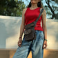 Braun-graue NIJENS Gassi-Tasche im Vintage-Look mit Lederdetails und Herz-Pfoten-Prägung, als Crossbody-Tasche getragen.