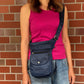 Frau trägt eine dunkelblaue wasserabweisende NIJENS Super-Hannover Gassi-Tasche als Crossbody. Praktische Hundetasche mit mehreren Fächern für Leckerlis, Handy und Zubehör.