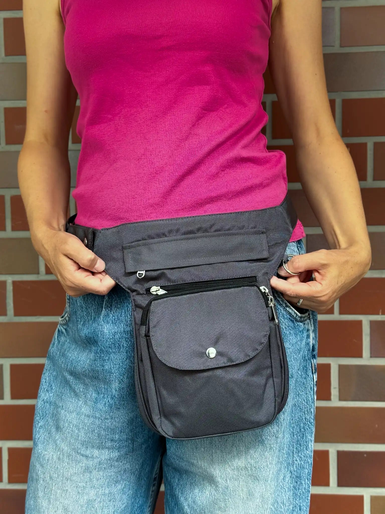 Dunkelgraue wasserabweisende NIJENS Super-Hannover Gassi-Tasche als Hüfttasche getragen. Funktionale Tasche mit mehreren Fächern für Hundezubehör und persönliche Gegenstände.