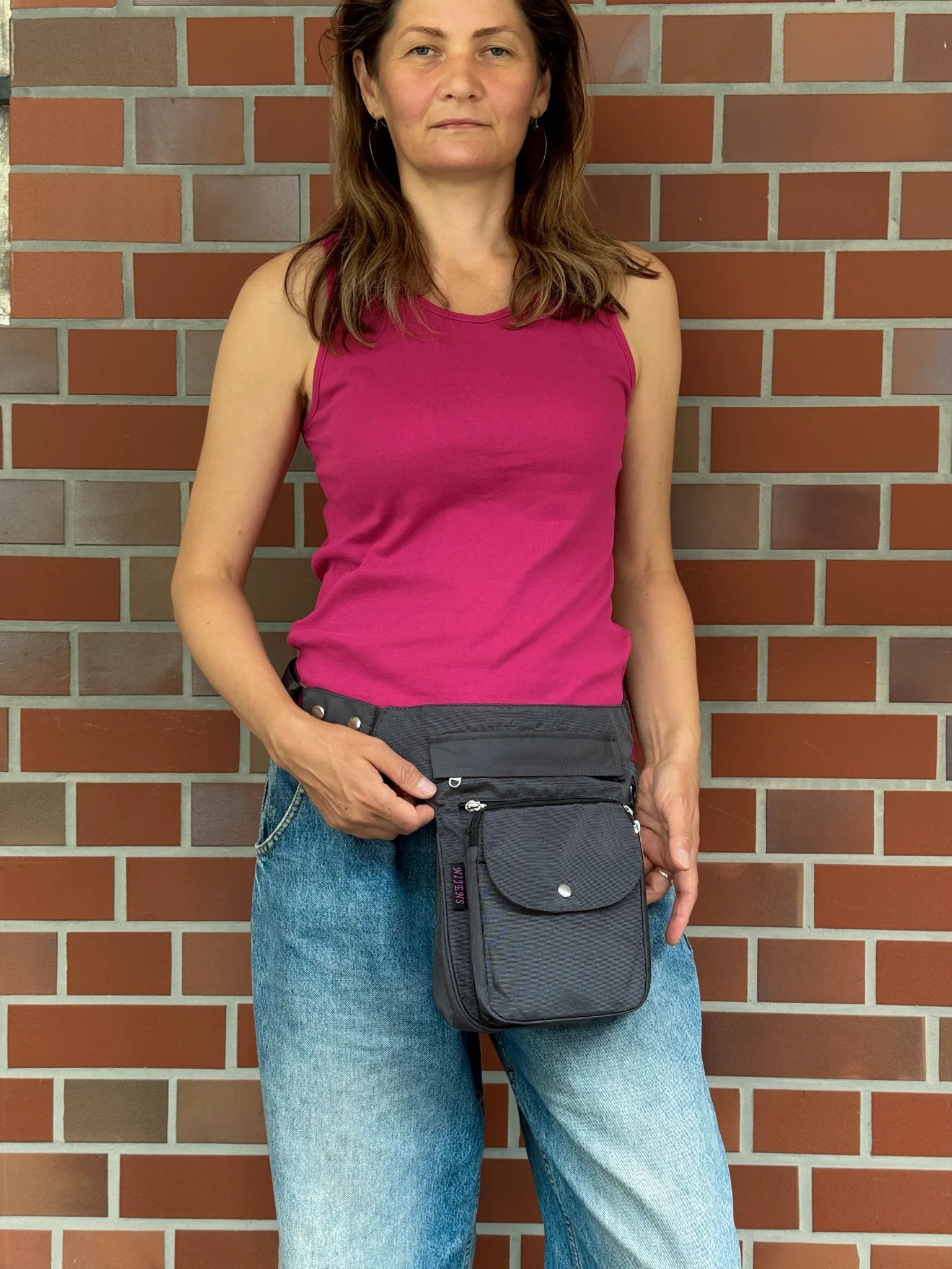 Graue wasserabweisende NIJENS Super-Hannover Gassi-Tasche als Hüfttasche getragen. Praktische Hundetasche mit viel Stauraum für Leckerlis, Kotbeutel und Smartphone.