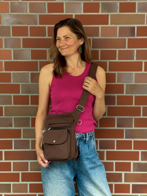 Braune NIJENS Super-Hannover Gassi-Tasche als Crossbodytasche getragen. Praktische Hundetasche mit viel Stauraum für Leckerlis und Smartphone.