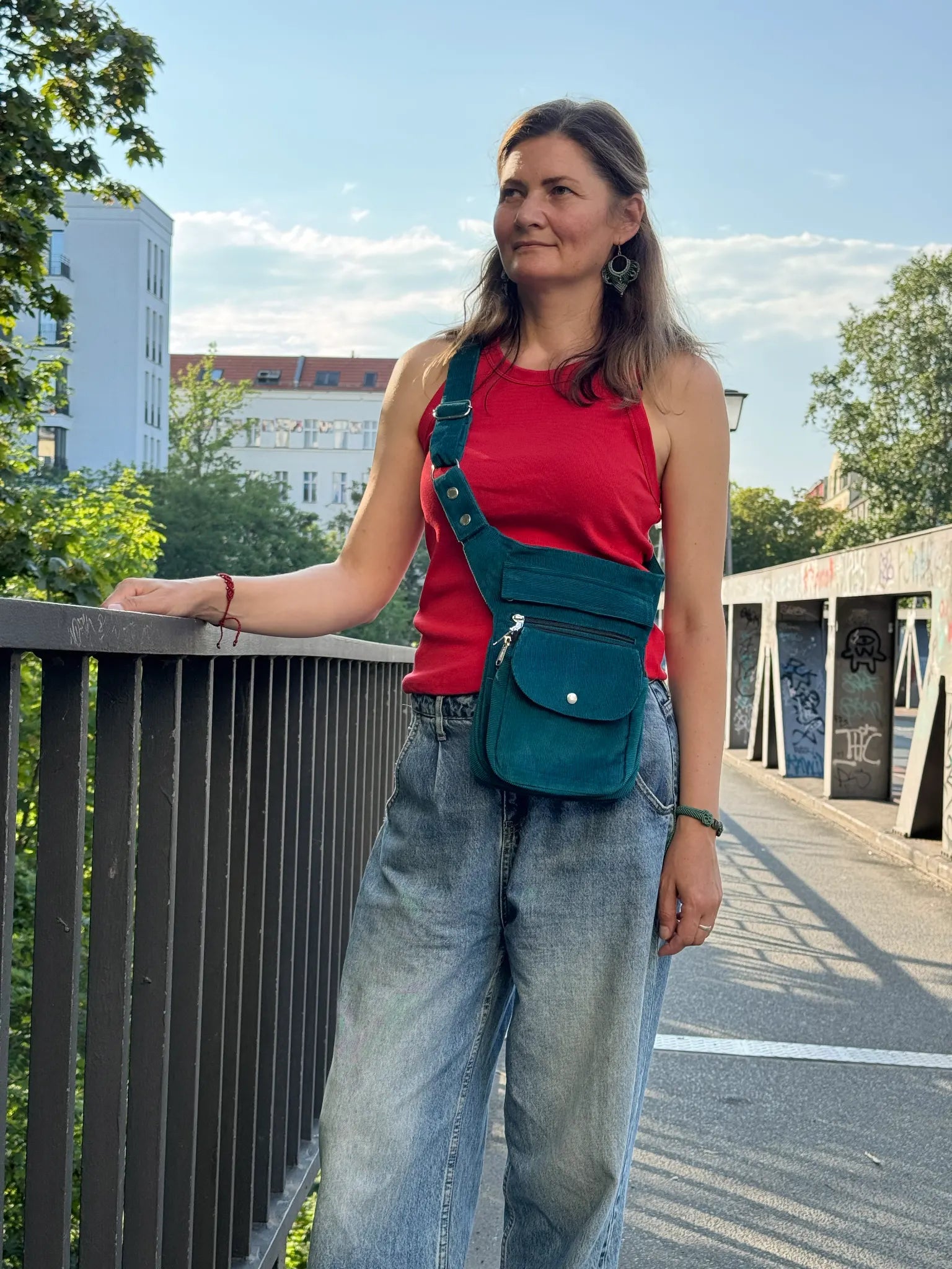 Frau trägt eine NIJENS Super-Hannover Gassi-Tasche aus Cord Petrol als Crossbody beim Spaziergang in der Stadt.