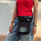 Schwarze NIJENS Super-Hannover Gassi-Tasche mit Mandala- und Pfotenstickerei als Crossbodytasche getragen – praktisch für Hundespaziergänge und Alltag.