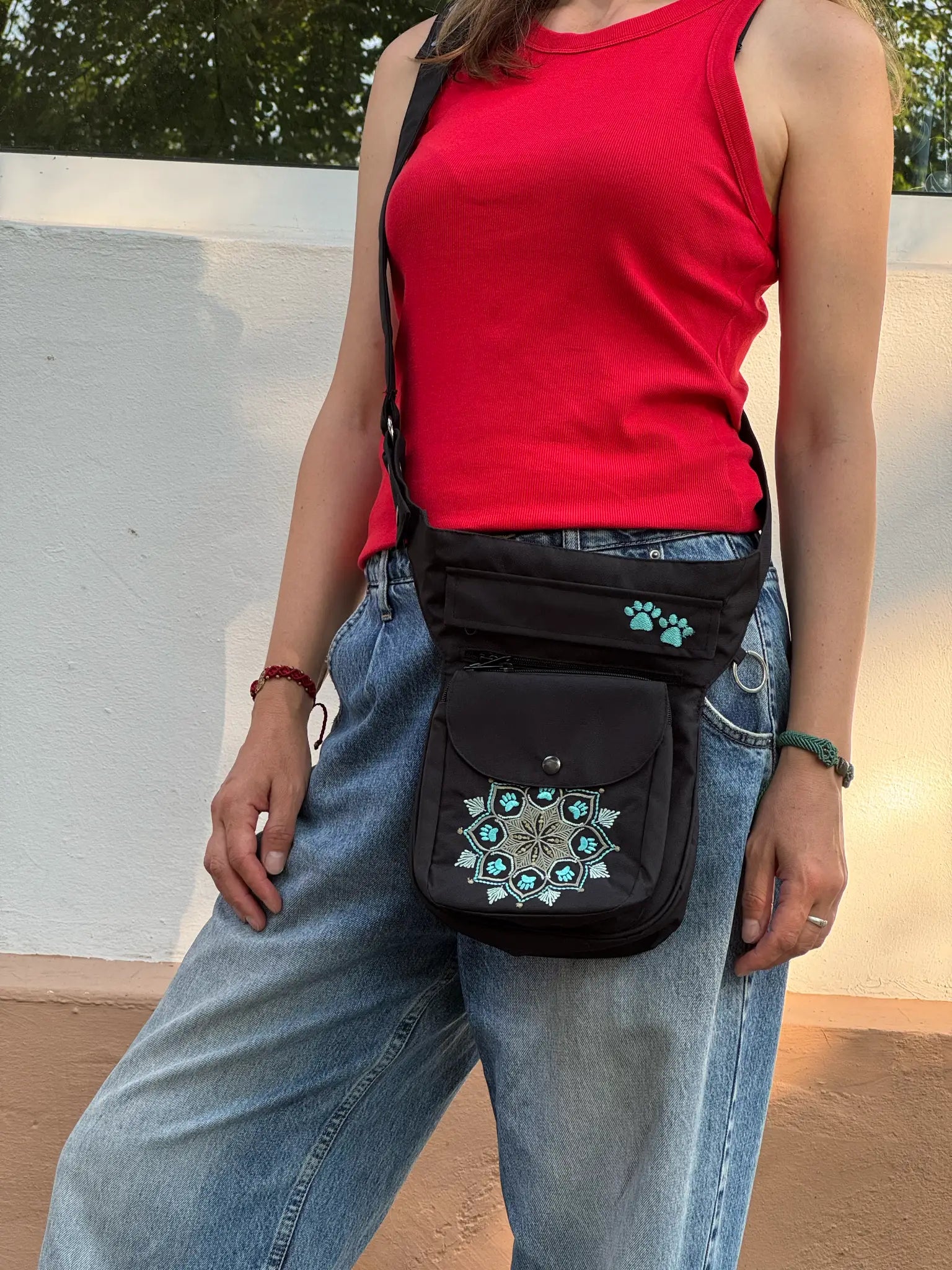 Schwarze NIJENS Super-Hannover Gassi-Tasche mit Mandala- und Pfotenstickerei als Crossbodytasche getragen – praktisch für Hundespaziergänge und Alltag.