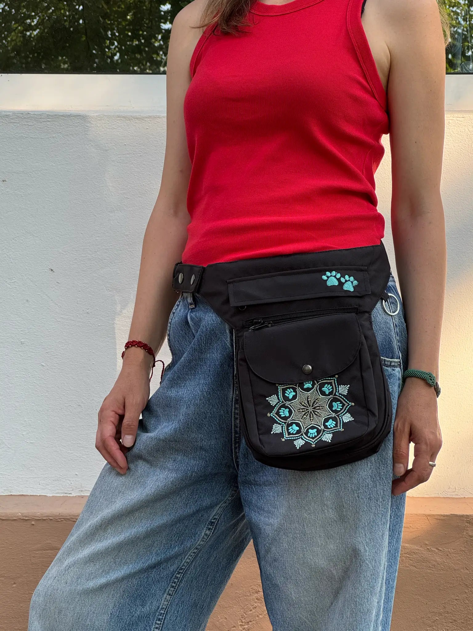 Schwarze NIJENS Super-Hannover Gassi-Tasche mit Mandala- und Pfotenstickerei als Hüfttasche getragen – praktisch für Hundespaziergänge und Alltag.