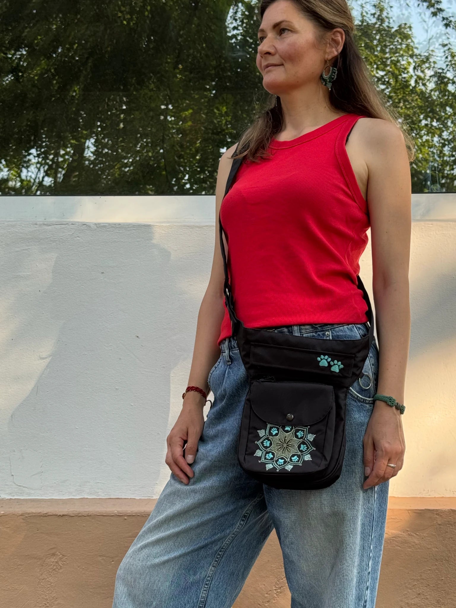 Schwarze wasserabweisende NIJENS Super-Hannover Gassi-Tasche mit Mandala Print als Crossbody getragen. Praktische Hundetasche mit viel Stauraum für Leckerlis, Kotbeutel und Smartphone.