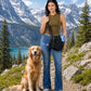 Frau mit anthraziter Cord-Gassitasche und integriertem Flaschenhalter neben einem Golden Retriever