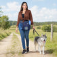 Frau mit dunkelblauer Nijens Hüfttasche im Mandala-Design und Sportschuhen spaziert mit einem Husky auf einem Feldweg in der Natur.