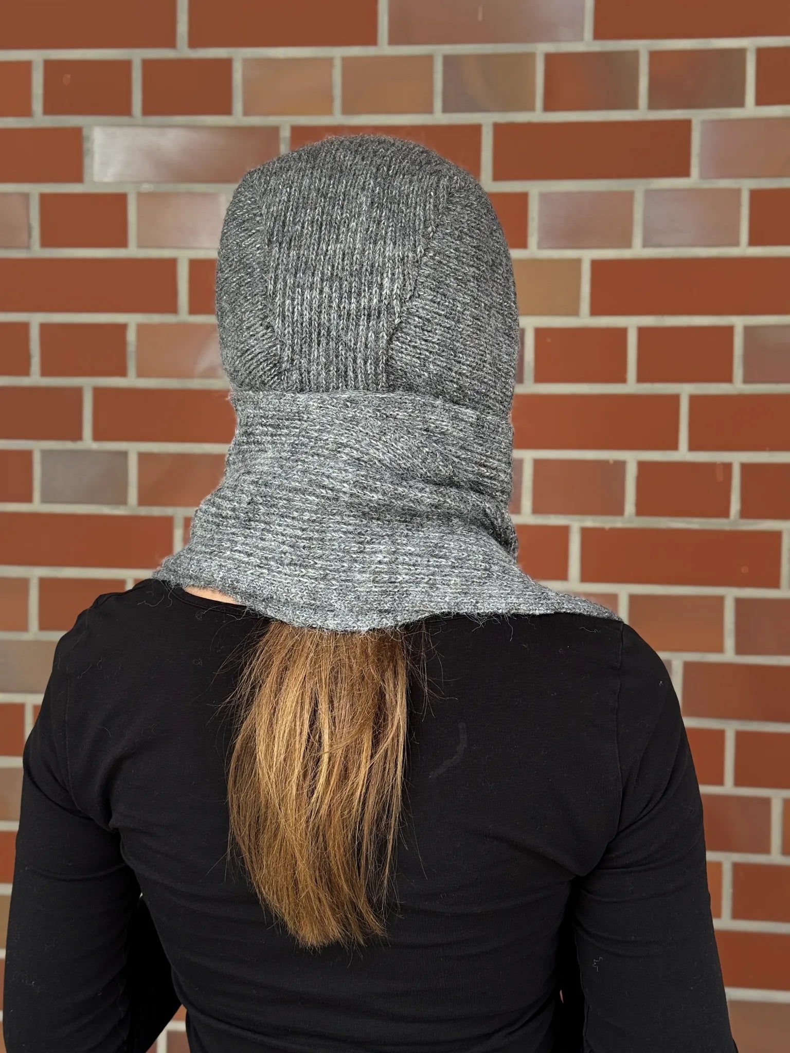 Nijens Balaclava in Dunkelgrau mit langen Schalenden am Model – Rückansicht