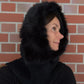 Nijens Balaclava Damen schwarz mit Kunstfell am Model – warmer Kapuzenschal für Winter. Seitenansicht.