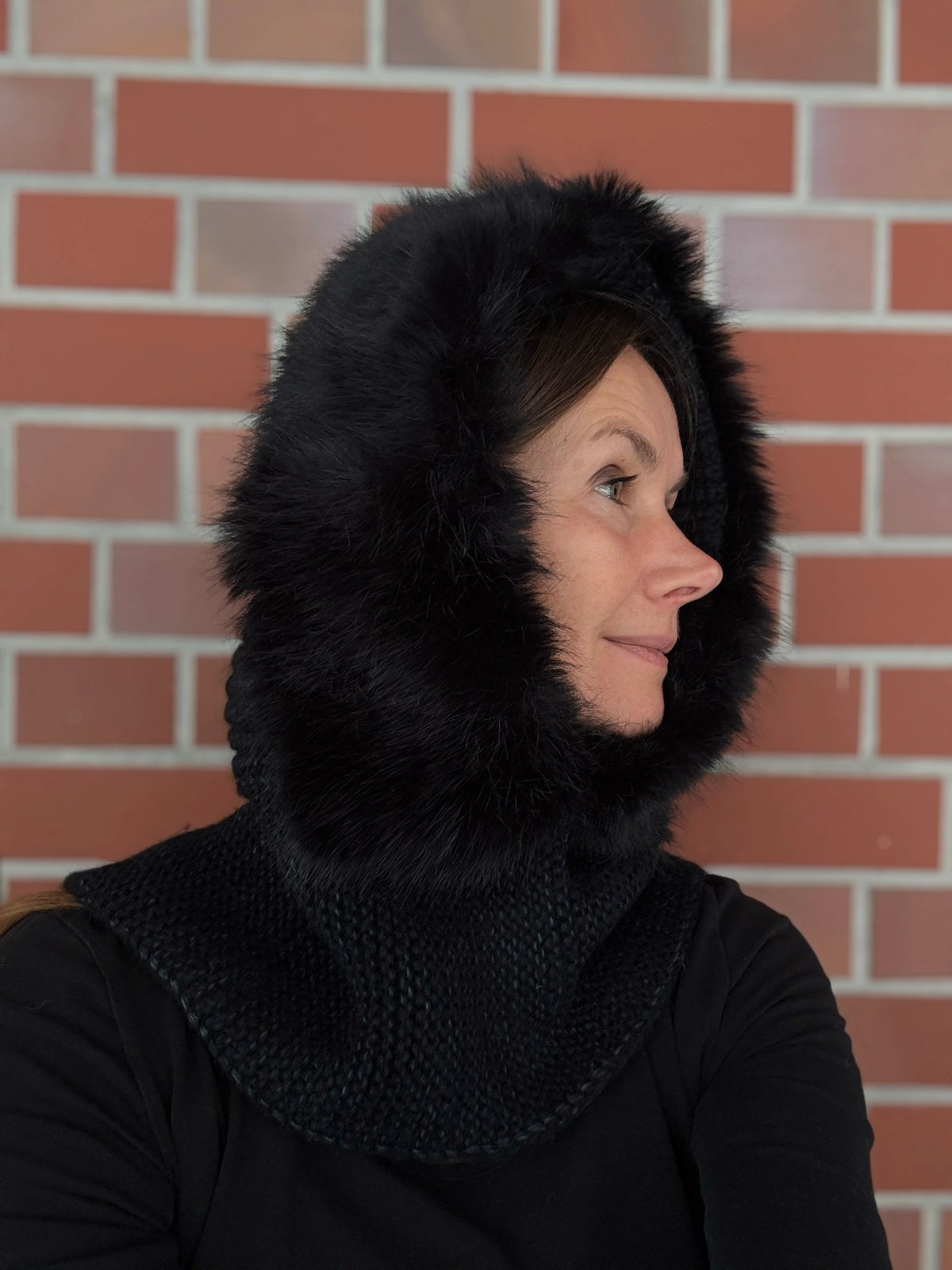 Nijens Balaclava Damen schwarz mit Kunstfell am Model – warmer Kapuzenschal für Winter. Seitenansicht.