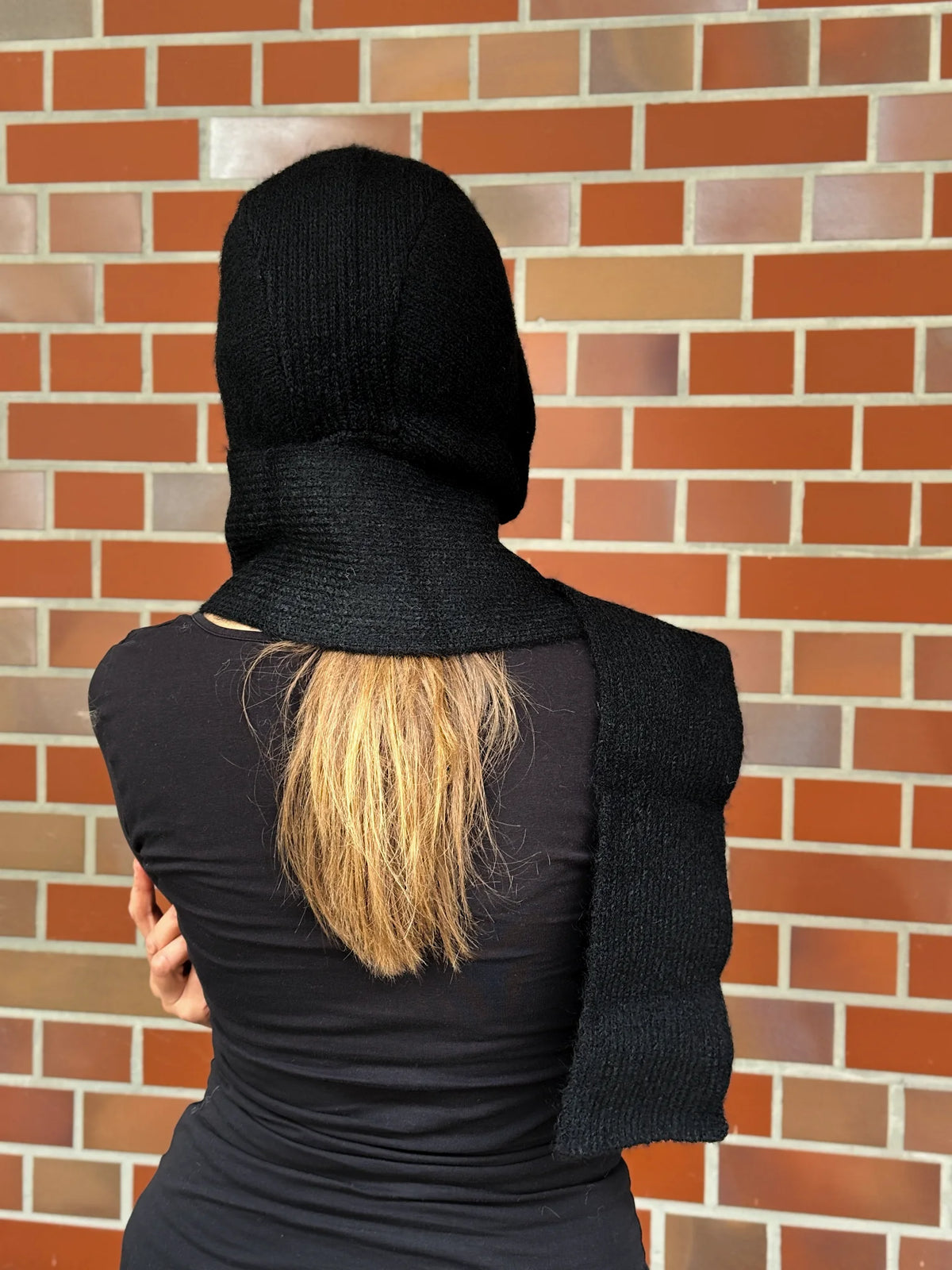 Nijens Balaclava in Schwarz mit langen Schalenden am Model – Rückansicht