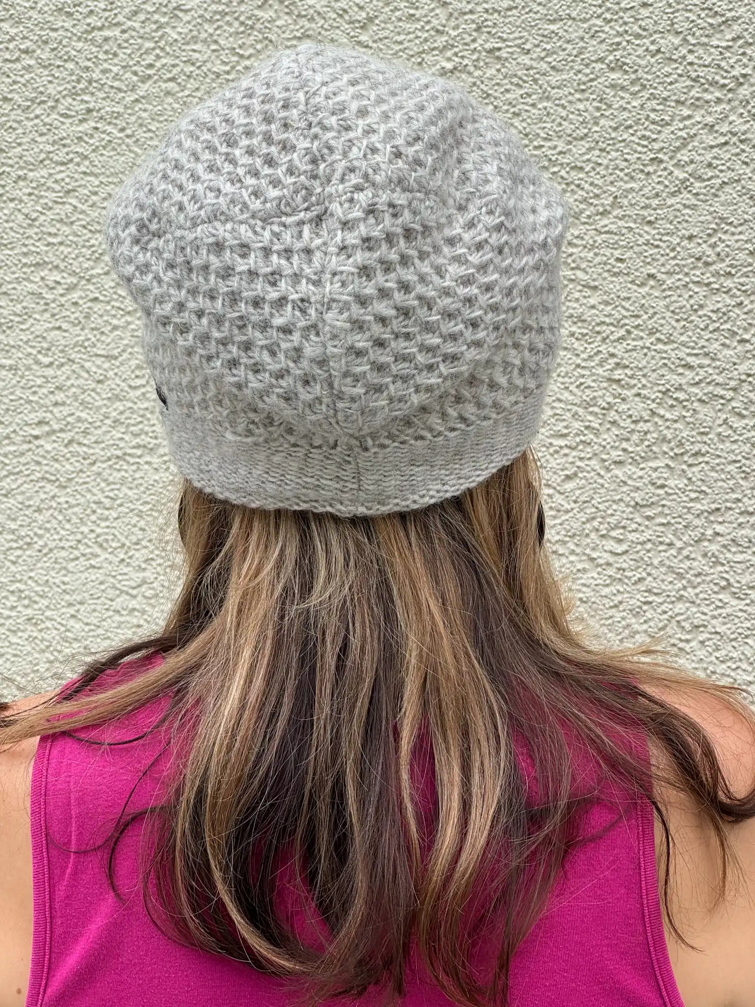 Rückansicht einer naturweißen Long Beanie aus Schurwolle mit grobem Strickmuster