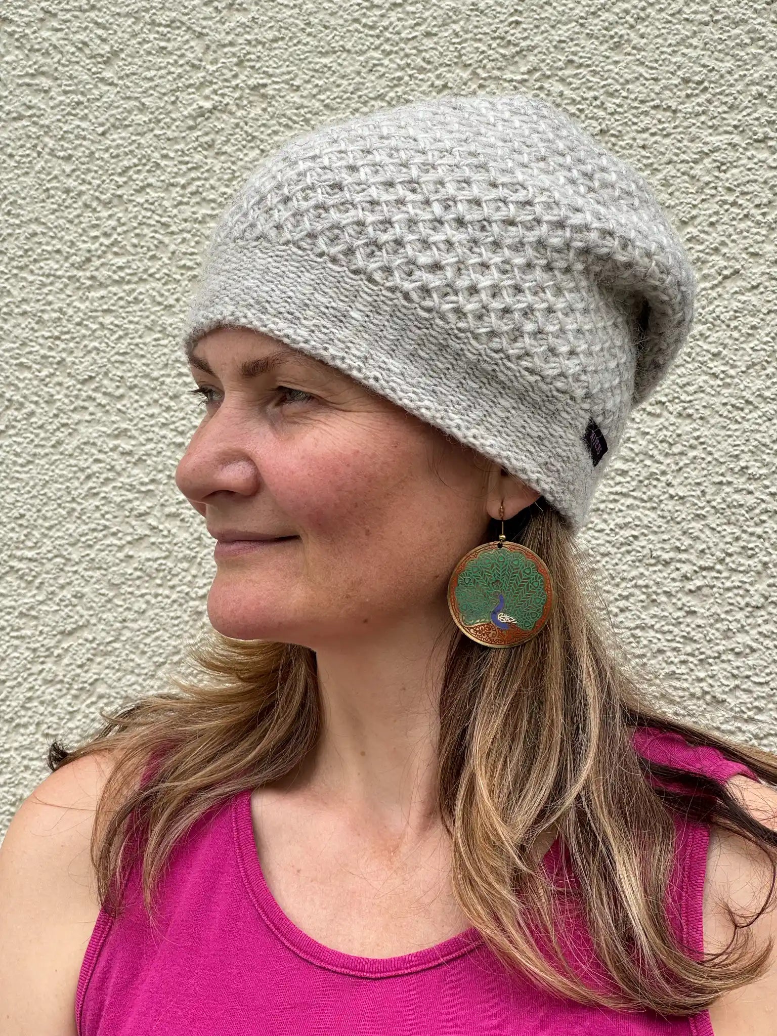 Seitenansicht einer naturweißen Long Beanie aus Schurwolle auf einem Modell