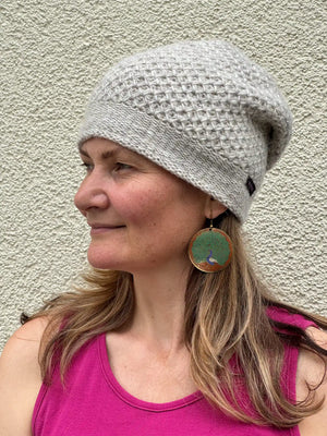 Seitenansicht einer naturweißen Long Beanie aus Schurwolle auf einem Modell