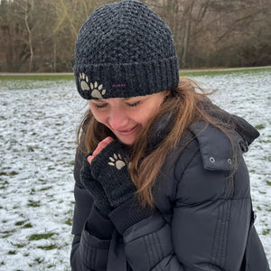 Eine Frau präsentiert Wollmütze, kurze Beanie Mütze aus Schurwolle in Anthrazit