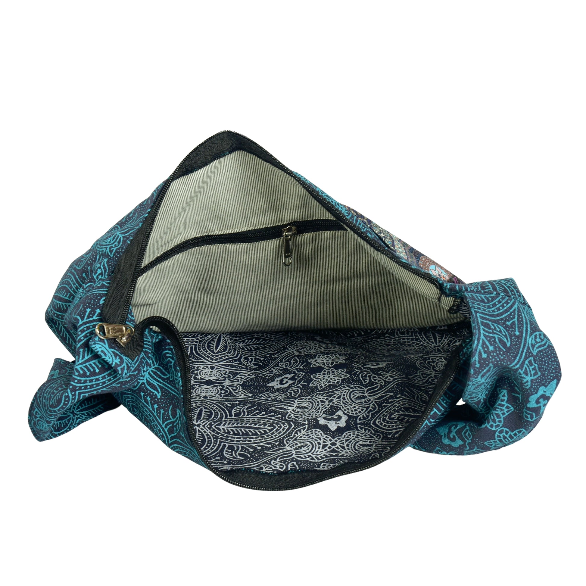 Geöffneter türkisfarbener Shopper zeigt großes Hauptfach mit innenliegendem Reißverschlussfach und gemustertem Futter.