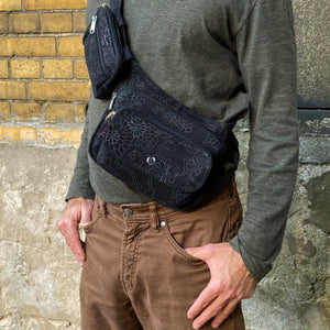 Gassi-Tasche Frankfurt in Schwarz mit Blumenmuster als Crossbody-Bag mit Gürtelverlängerung getragen