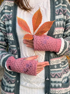 Model präsentiert handgestrickte Pulswärmer, Armstulpen mit Zwei-Pfoten-Stickerei aus Schurwolle in Altrosa. Innenfutter: Fleeceeinsatz. Spalt für Daumen.