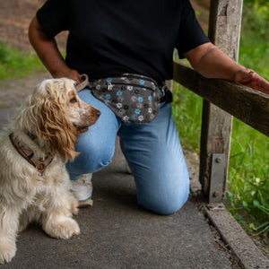 Frau mit Hund beim Spaziergang im Wald mit Nijens Gassi-Bauchtasche mit Pfotenmuster