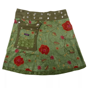 Wenderock aus Baumwolle, Grün mit roten Blumen Motiven. Der Rockbund hat eine doppelte Druckknopfleiste und ist größenverstellbar. An der Seite gibt es eine abnehmbare Stofftasche mit Reißverschlussfach und Einsteckfach welches durch einen Überschlag mit Klett verschließbar ist.