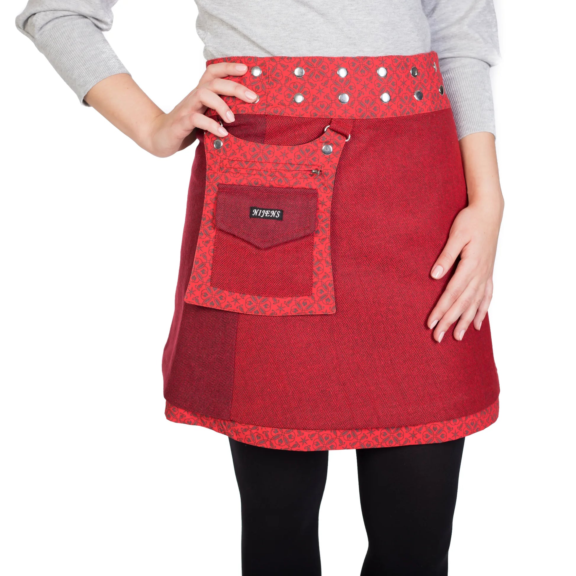 Roter Tweed-Wickelrock von Nijens mit dekorativer Druckknopfleiste und aufgesetzter Tasche, getragen von Model. Nijens Shop.