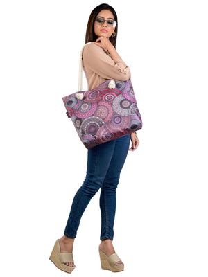 Studioaufnahme: Frau trägt eine  Strandtasche in Rosatönen mit Mandala-Design  – funktional und auffällig.
