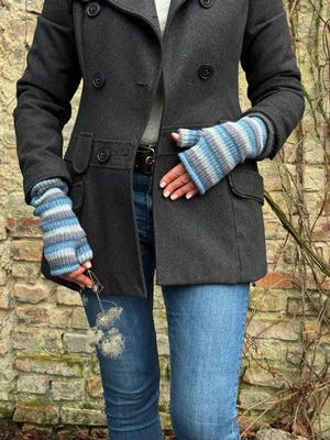 Model präsentiert Armstulpen, Pulswärmer aus Schurwolle, gestreift in Blautönen mit Daumen und Innenfutter aus Fleece.