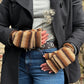 Model präsentiert fingerfreie Handschuhe aus Wolle gestreift in Brauntöne, welche sich mit einer Fingerkappe zu Fäustlingen umwandeln lassen.