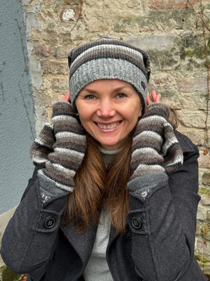 Model präsentiert Long Beanie Mütze  Schurwolle Gestreift - Satti Hat C-21 und fingerfreie Handschuhe aus Wolle gestreift in Braun, Grautöne, welche sich mit einer Fingerkappe zu Fäustlingen umwandeln lassen.
