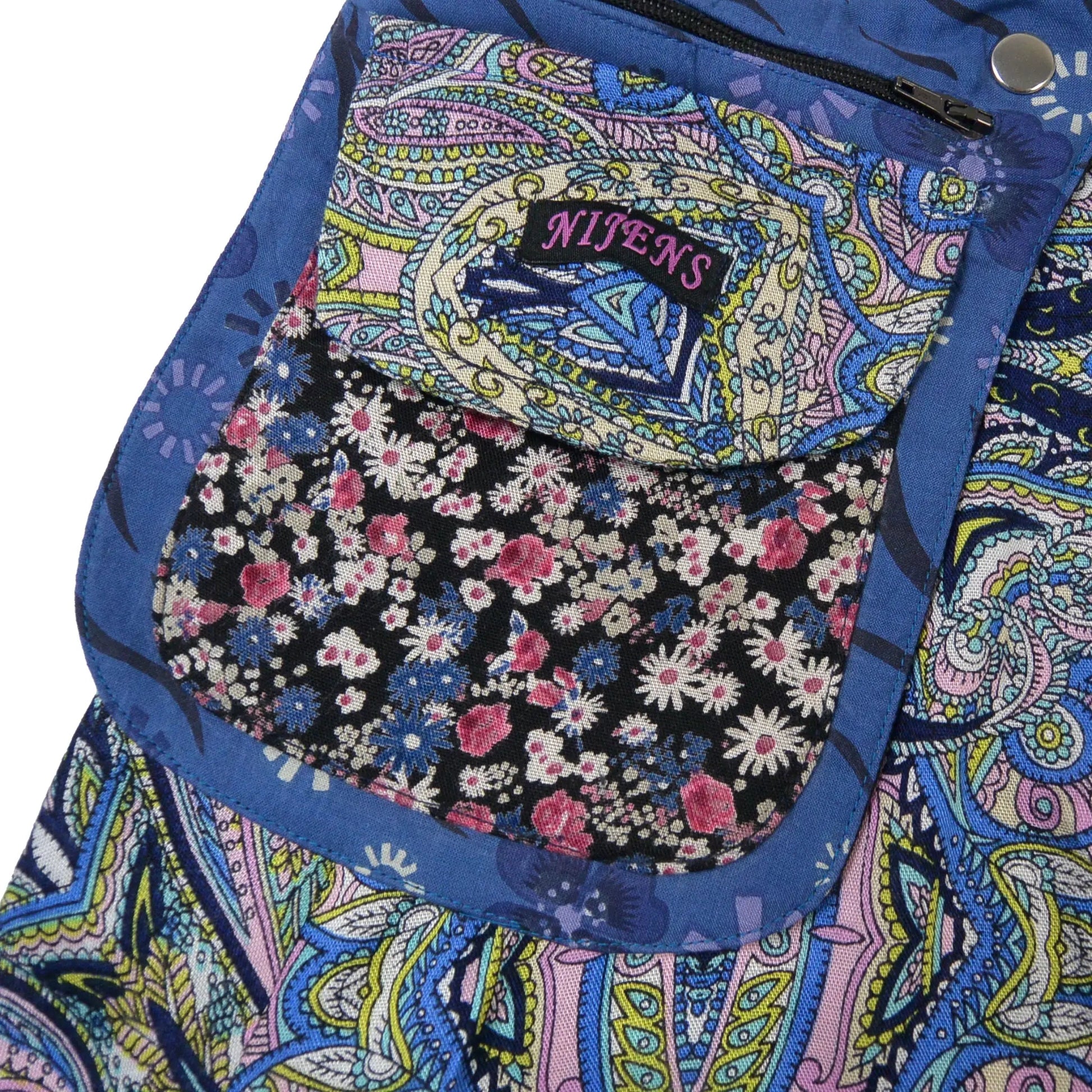 Nahaufnahme der Nijens-Tasche mit Paisley-Klappe in Blau und pink-schwarzem Blümchenmuster.