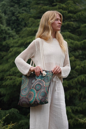 Frau trägt eine große Nijens Strandtasche mit grünem Mandala-Muster und dicken Kordelgriffen – stylisch und praktisch für Alltag, Reisen oder Strand.