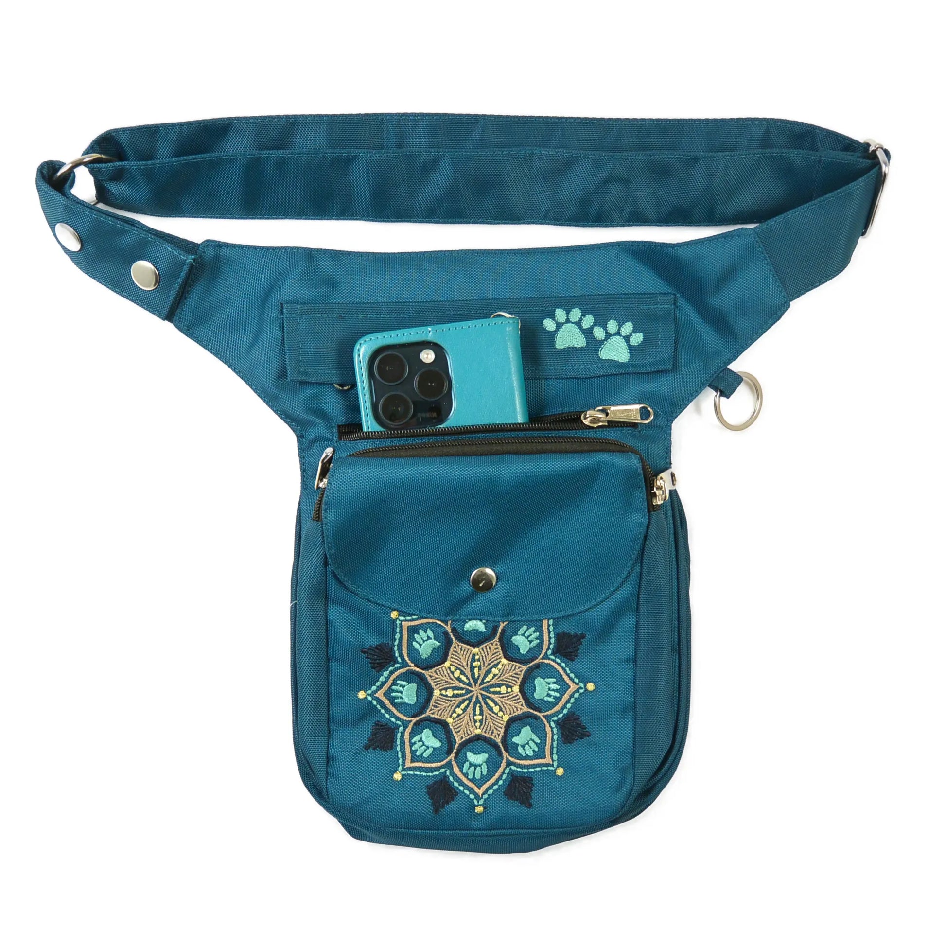 Gassitasche aus wasserabweisendem Nylonstoff Petrol-Türkis mit Blumenpfotenmandala-Stickerei. 3 Reißverschlussfächer und ein Einsteckfach vorne, welches mit einem Druckknopf an der Überlappung geschlossen wird. Handyfach.