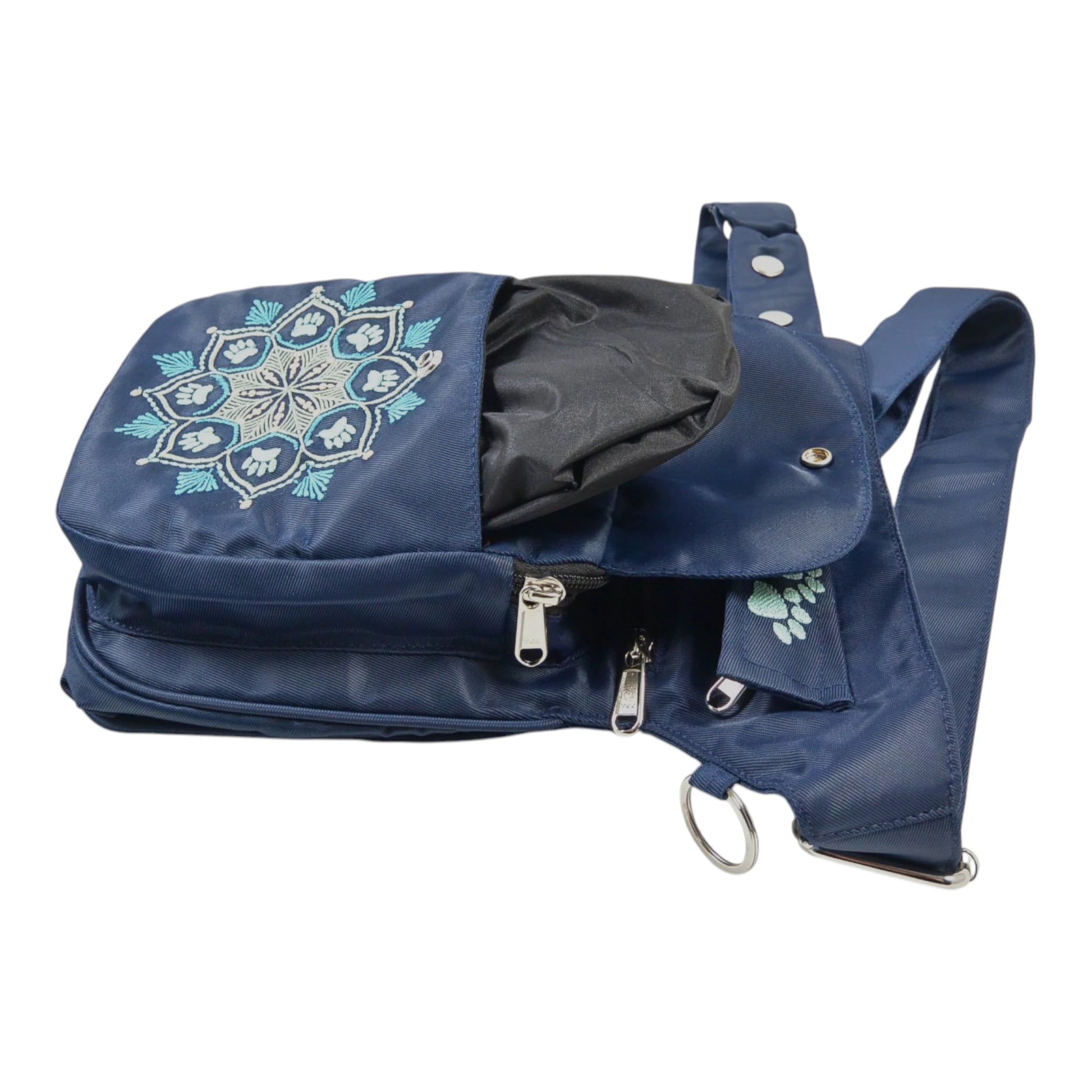 Gassi-Tasche aus wasserabweisendem Nylonstoff in Dunkelblau mit Pfoten-Mandalastickerei. Diese Tasche verfügt über zwei Leckerlifächern mit wasserabweisendem und waschbarem Innenfutter. Bild 2.