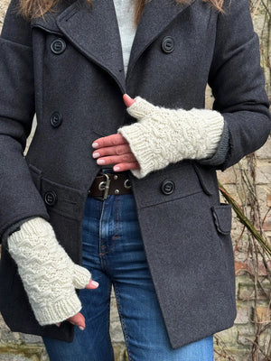 Das Model präsentiert Gestrickte Pulswärmer, Stulpen mit Daumen aus Wolle Weiß.