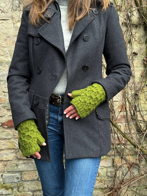 Das Model präsentiert Gestrickte Pulswärmer, Stulpen mit Daumen aus Wolle Grün.