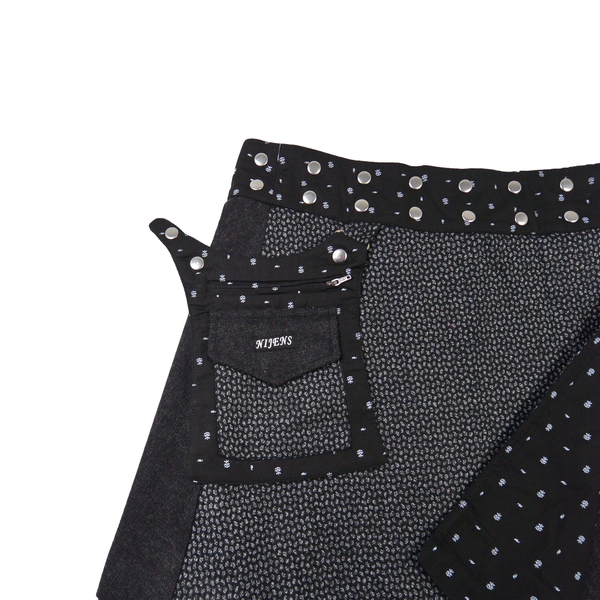 Detailansicht Tasche und Bund des schwarzen Tweed-Wickelrocks mit Druckknöpfen von Nijens