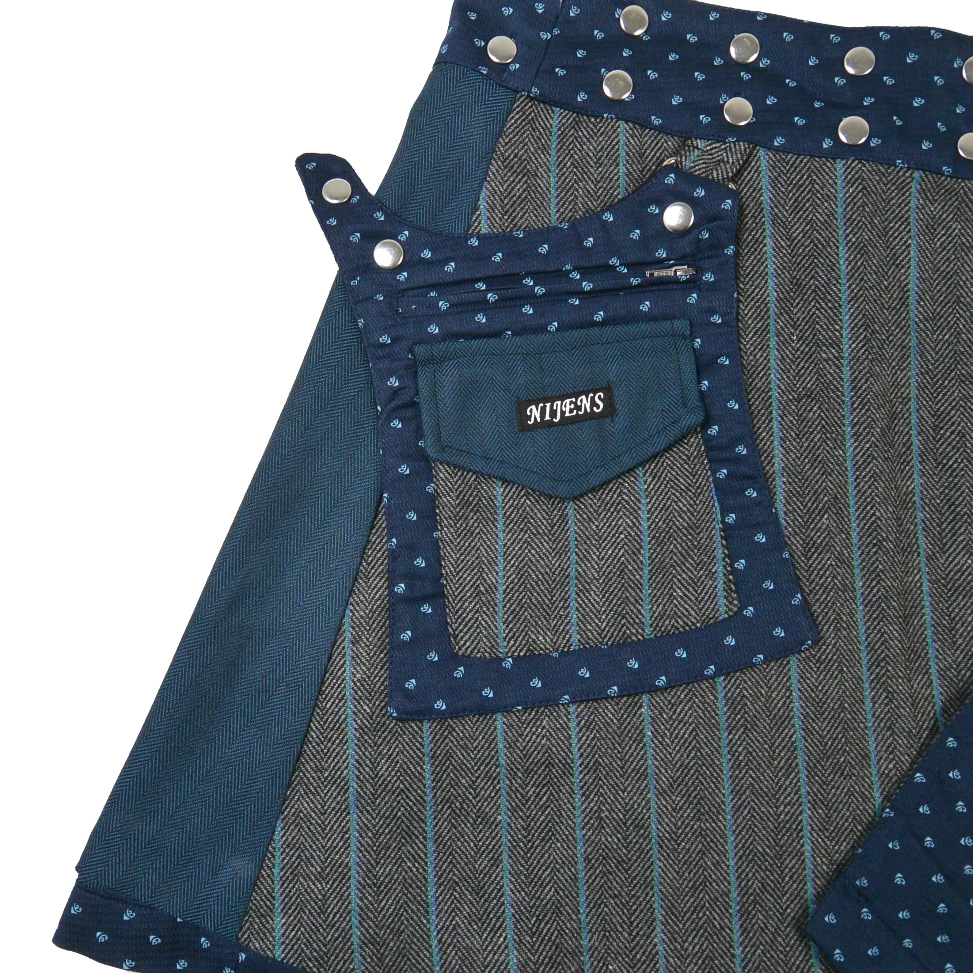 Detailansicht Tasche und Bund des petrol-blauen Tweed-Wickelrocks mit Druckknöpfen von Nijens