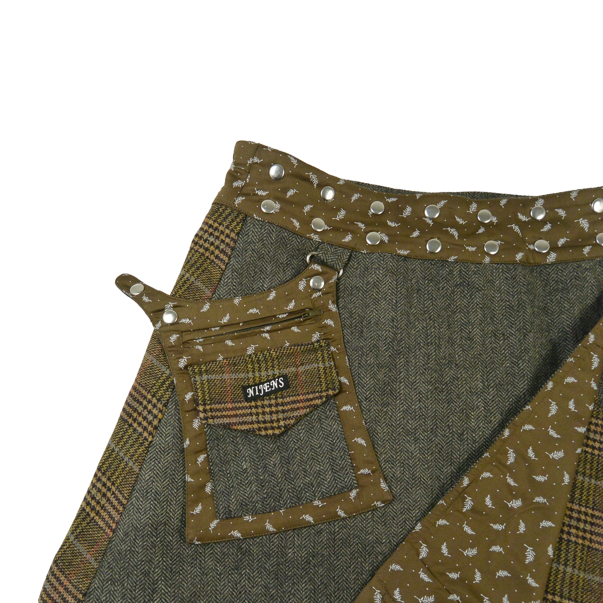 Detailansicht Tasche und Bund des olivgrünen Tweed-Wickelrocks mit Druckknöpfen von Nijens