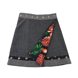 Frontseite des Wenderocks aus Tweed mit grauem Muster und farbenfroher Innenseite mit Blättern und Früchten. Nijens Shop.