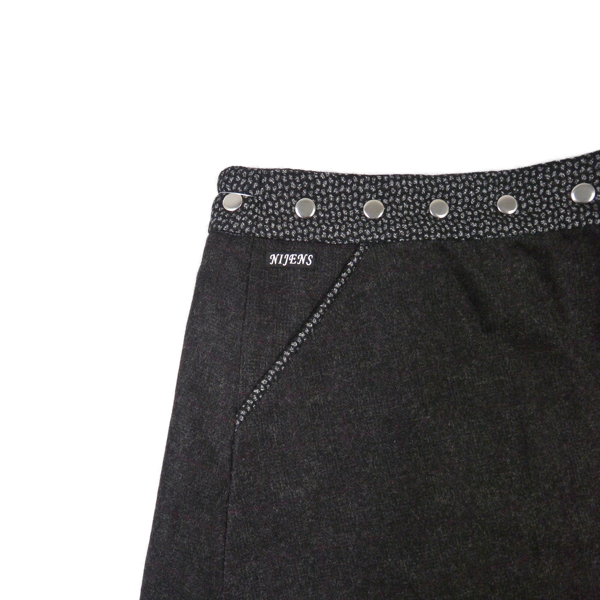 Detailansicht des dunkelgrauen Wenderocks aus Tweed mit zarter Struktur und Druckknopfleiste